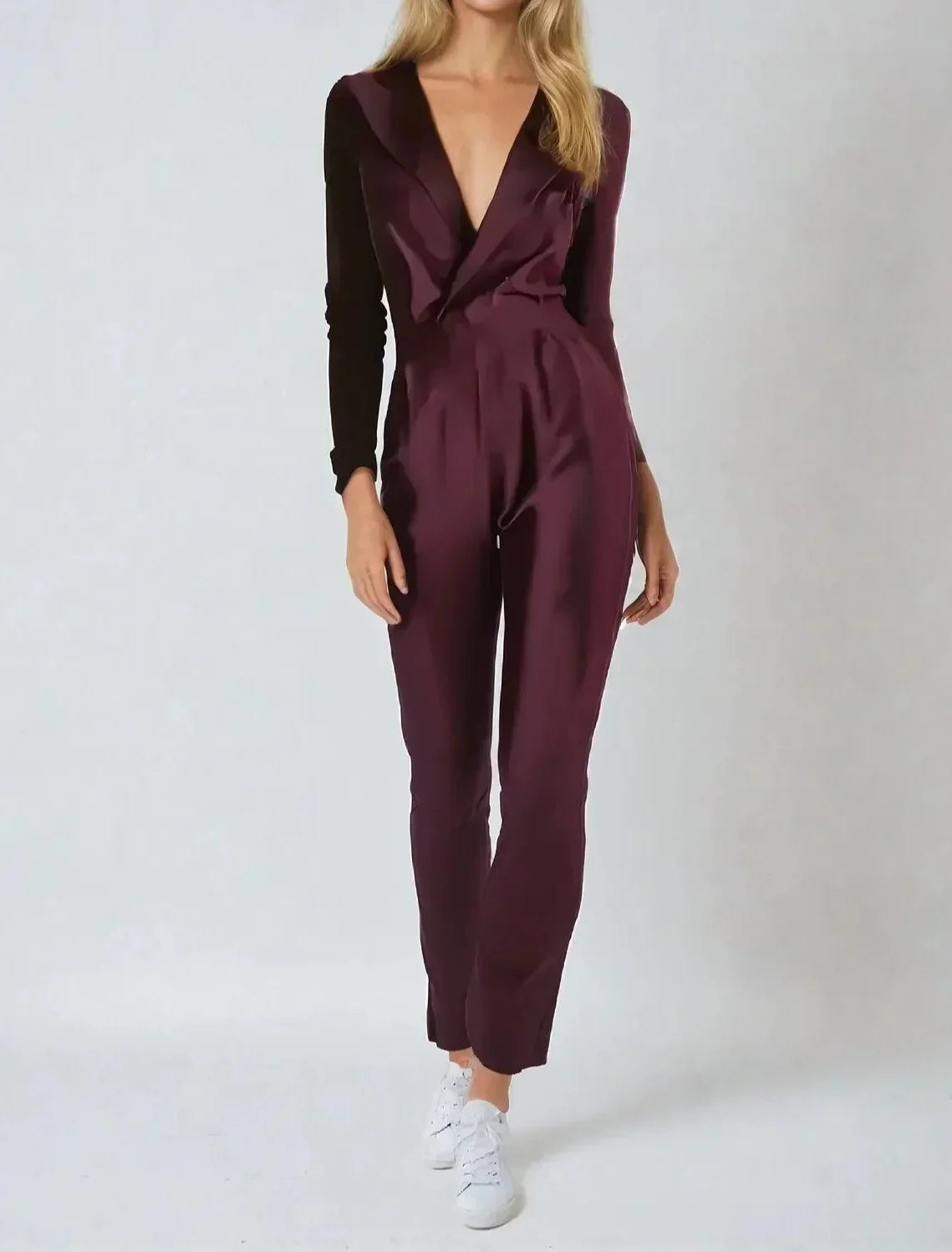 Woman wearing a burgundy jumpsuit on a white background