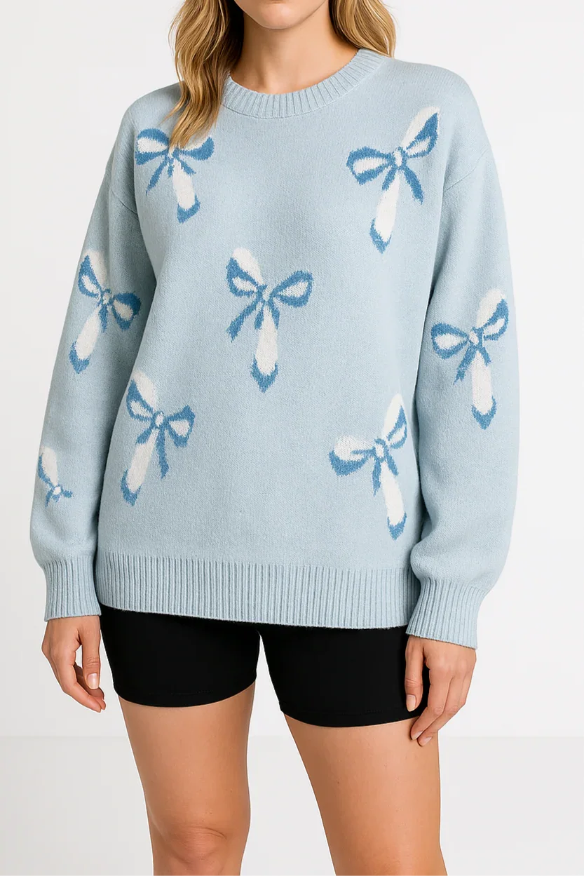 Woman wearing a light blue sweater with bow patterns on a white background