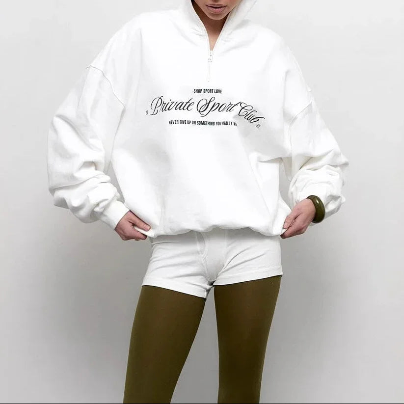 Person wearing a white sweatshirt with text on a plain background