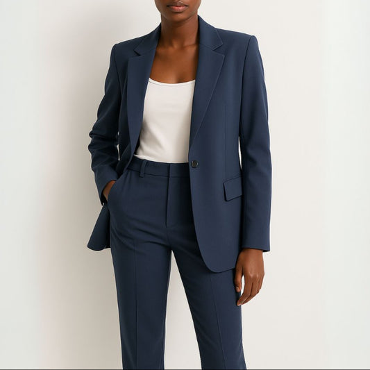 Woman wearing a navy suit with a white top on a light background