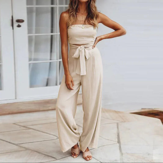 Woman wearing a beige strapless jumpsuit standing on a patio.