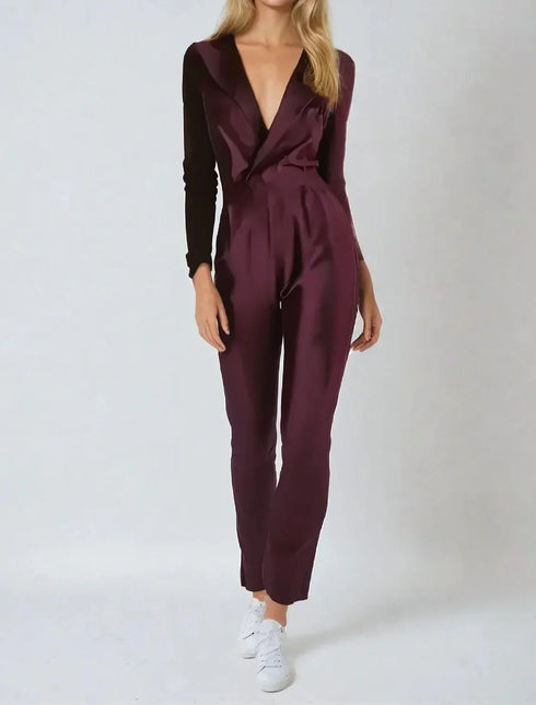 Woman wearing a burgundy jumpsuit on a white background
