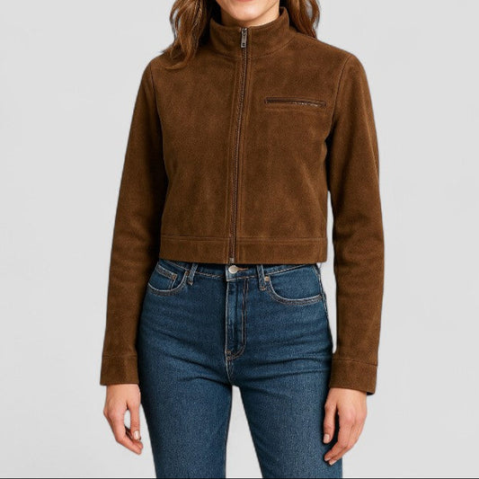 Woman wearing a brown jacket and blue jeans on a light gray background