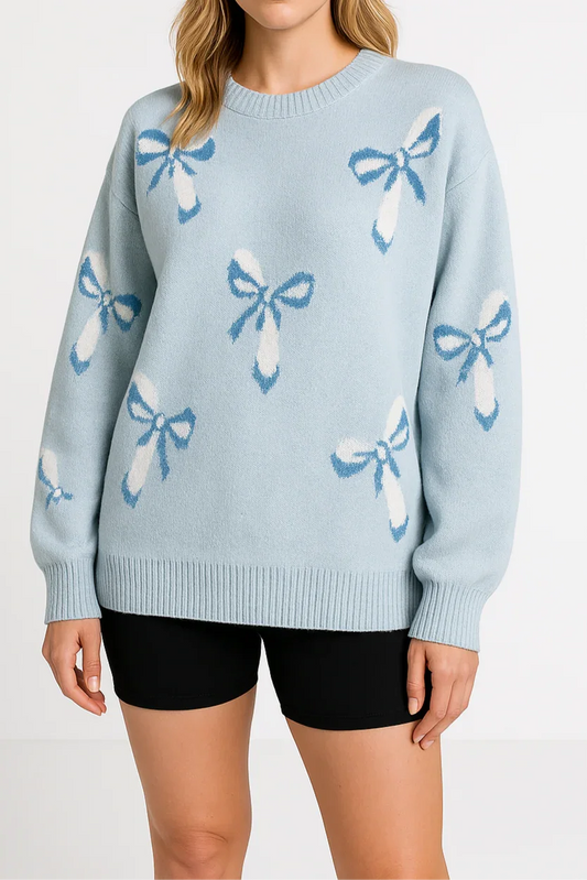 Woman wearing a light blue sweater with bow patterns on a white background
