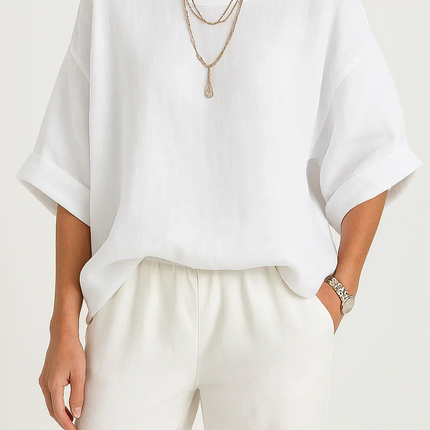 Woman wearing a white top and beige hat on a plain background