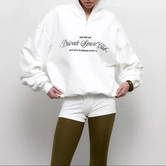 Person wearing a white sweatshirt with text on a plain background