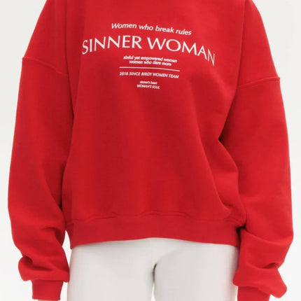 Woman wearing a red sweatshirt with text on a white background